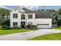 Beautiful two-story home with a well-manicured lawn, fresh exterior paint, and attached two car garage at 1670 Burnt Oak Way, Dacula, GA 30019