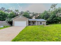 Charming single-story home with a well-maintained lawn and attached garage, perfect for suburban living at 1333 Trailwater Chase Nw, Acworth, GA 30102