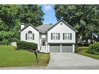 Charming two-story home with a well-manicured lawn, gray trim, and an attached two-car garage at 1361 Chatley Way, Woodstock, GA 30188