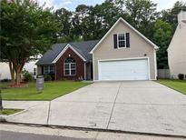 Charming home featuring a two-car garage, well-manicured lawn, and traditional architecture at 4920 Markim Forest Ln, Sugar Hill, GA 30518