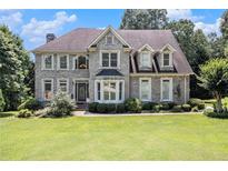 Charming two-story home with stone facade, mature trees, and well-manicured lawn at 317 Saint Pauls Ct, Stockbridge, GA 30281