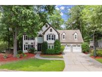 Charming two-story home with a well-manicured lawn, lush landscaping, and a two-car garage at 4300 May Apple Dr, Alpharetta, GA 30005
