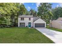 Charming two-story home with a well-maintained lawn, a blue front door, and an attached garage at 1841 Surrey Hill Cir, Lawrenceville, GA 30044
