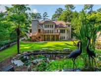 Expansive backyard featuring lush greenery, a charming pond, and a spacious deck perfect for outdoor relaxation at 1865 Mason Mill Rd, Decatur, GA 30033
