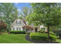 Charming two-story home featuring a welcoming front porch and beautifully landscaped front yard at 4275 Green Summers Dr, Cumming, GA 30028
