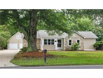 Charming single-Gathering home with stone accents, manicured lawn, and mature tree at 6109 N Main Se St, Acworth, GA 30101