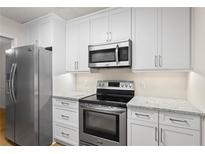 Well-lit kitchen featuring stainless steel appliances, white cabinets, and granite countertops at 111 Abingdon Way, Sandy Springs, GA 30328