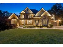 Beautiful two-story brick home with manicured lawn, professional landscaping, and elegant lighting at 5114 Brendlynn Dr, Suwanee, GA 30024