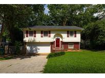 Charming two-story home with red shutters, a well-manicured lawn, and an attached garage at 2831 Carolyn Se Dr, Smyrna, GA 30080