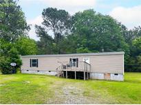 Exterior view of home featuring a covered porch, tan siding, and a well maintained lawn at 2567 Hancock Rd, Social Circle, GA 30025