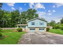 Charming split-level home with a well-maintained lawn and two-car garage at 6889 Kingsboro Dr, Lithia Springs, GA 30122