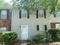 Charming townhome featuring a light exterior with dark shutters, complemented by well-maintained landscaping at 8957 Stonebridge Blvd, Douglasville, GA 30134