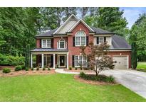 Charming two-story brick home with well-manicured lawn and inviting front porch at 4401 Madison Woods Nw Dr, Marietta, GA 30064