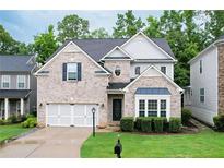 Charming two-story home with brick facade, manicured lawn, and attached two-car garage at 2940 Bentbill Xing, Cumming, GA 30041