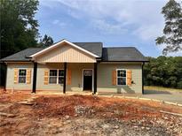 Charming single-story home features neutral siding, a welcoming front porch, and complementary shutters at 389 Campground School Rd, Dallas, GA 30157