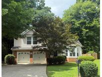Charming two-story home with a two-car garage and well-manicured landscaping at 1035 Towne Manor Nw Ct, Kennesaw, GA 30144