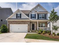 Charming two-story home with stone accents, a well-manicured lawn, and a welcoming front porch at 338 Boundless Ln, Canton, GA 30114