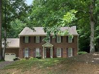 Traditional two-story brick home with symmetrical windows and a manicured front yard surrounded by mature trees at 4782 Donnegal Se Ct, Mableton, GA 30126