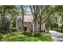 Charming two-story home with lush landscaping and mature trees providing shade and privacy at 2375 Hyde Park Nw Ct, Atlanta, GA 30318