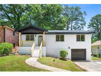 Charming brick home featuring a freshly painted exterior, updated trim, and an inviting front porch at 264 Howell Sw Ter, Atlanta, GA 30331