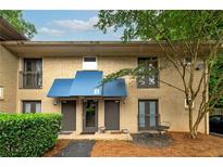 Charming townhouse exterior with brick facade, blue awnings, and manicured landscaping at 2023 Oakview Se Rd # 226, Atlanta, GA 30317
