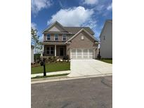 Beautiful brick two-story home featuring an attached two car garage, landscaping, and a well maintained lawn at 4266 Mulberry Pass Ct, Hoschton, GA 30548
