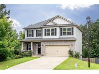 Charming two-story home features a manicured lawn and neutral siding with black shutters at 3302 Bellingham Way, Lithia Springs, GA 30122