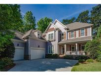 Charming two-story home featuring a welcoming front porch, attached garages, and a well-maintained landscaped yard at 3698 Lakeview Drive, Tucker, GA 30084