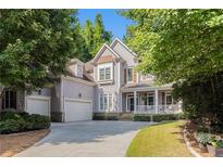 Charming two-story home features a covered porch, two-car garage, and beautifully landscaped front yard at 3698 Lakeview Drive, Tucker, GA 30084