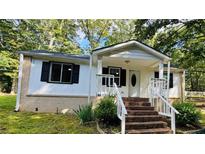Charming single-story home featuring a brick foundation and a covered front porch with brick steps at 6197 Union Grove Rd, Lithia Springs, GA 30122
