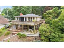 Charming home featuring a spacious deck, lower-level patio, and lush greenery offering an inviting outdoor space at 6381 Lakeview Dr, Buford, GA 30518