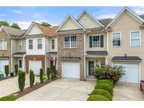 Charming townhome with brick accents, tidy landscaping, and attached one-car garage at 2964 Greyhawk Ln, Cumming, GA 30040