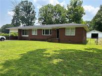 Charming brick home with a well-manicured lawn and mature trees at 3561 Clay Rd, Austell, GA 30106