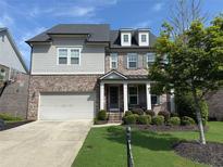 Charming two-story home with a manicured front yard, a brick facade, and a two-car garage at 4130 Millbrook Ct, Suwanee, GA 30024