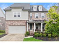 Charming two-story home features a mix of brick and siding, a welcoming front porch, and a well-manicured lawn at 4130 Millbrook Ct, Suwanee, GA 30024