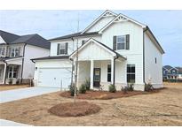 Charming two-story home featuring white siding, a covered entry, and a convenient two-car garage at 2674 Mourning Dove Drive (Lot 37), Grayson, GA 30017