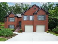 Beautiful brick home featuring a two-car garage, landscaped yard, and inviting front entrance at 655 Golden Meadows Ln, Suwanee, GA 30024