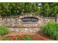 Stone monument sign for Brookview Manor with manicured flowerbeds and mature trees, marking the community entrance at 2403 Wistful Way, Marietta, GA 30066