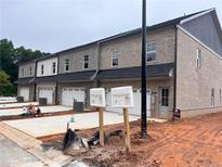 A newly constructed townhome with light brick, a garage, and landscaping that is still in progress at 3232 Cyrus Creek Dr, Kennesaw, GA 30152
