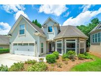 Charming home featuring a two-car garage, stone accents, manicured landscaping, and inviting curb appeal at 825 Chalet Hls, Mcdonough, GA 30253