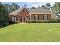 Charming single-story brick home featuring a lush green lawn, manicured shrubs, and inviting curb appeal at 5831 Wembley Dr, Douglasville, GA 30135