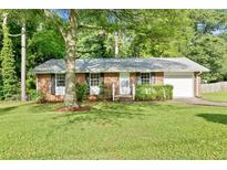 Charming single-story brick home with a well-manicured lawn, mature tree and an attached single car garage at 6671 Gano Dr, Riverdale, GA 30274