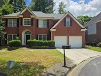 Charming two-story brick home featuring a well-manicured lawn and a two-car garage at 2670 Henderson Chase Ct, Tucker, GA 30084