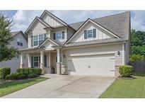 Charming two-story home featuring a two-car garage, manicured lawn and neutral color palette at 3940 Frasier Dr, Cumming, GA 30028