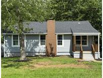 Charming home featuring a brick chimney, gray siding, a covered front porch, and a well-maintained lawn at 2039 Gober Ave Se, Smyrna, GA 30080
