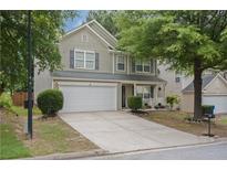 Two-story home with gray siding, white trim, two-car garage, and landscaped front yard on a sunny day at 3347 Sable Run Rd, Atlanta, GA 30349