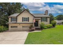 Charming two-story home with a manicured lawn and a two-car garage at 388 Rose Creek Pl, Woodstock, GA 30189
