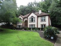 Charming two-story home featuring a manicured lawn and a welcoming front entrance, set amongst mature trees at 5820 Elm Tree Dr, Buford, GA 30518