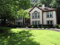 Charming two-story home featuring a well-manicured lawn and meticulously landscaped garden beds at 5820 Elm Tree Dr, Buford, GA 30518