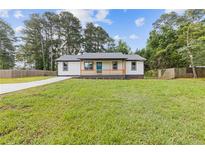 Charming single-story home featuring a lovely front porch, a well-maintained lawn and a freshly poured concrete driveway at 2310 Whitehead Place Dr, Suwanee, GA 30024